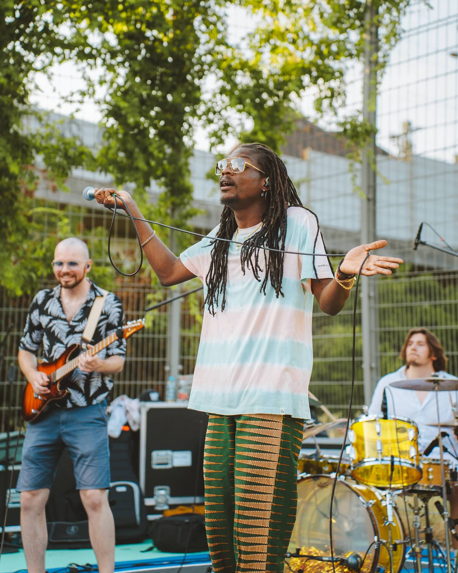 Fofana Jo performing  with his band on a soccer field 